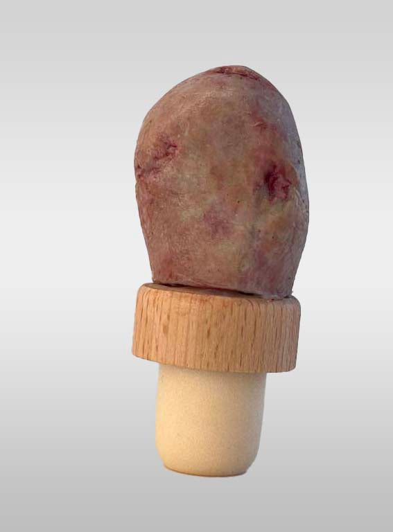 Zombie severed toe with sparkly red nail polish and green rotten skin on a bottle stopper cap